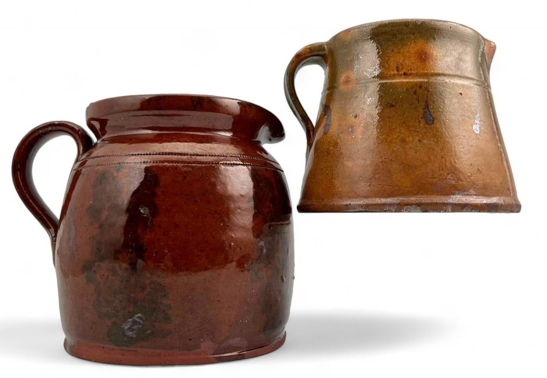Two Early American Glazed Redware Pitchers: Two Early American Glazed Redware Pitchers. Smallest approximately 5.0L x 5.5W x 4.25H in. Largest approximately 5.5L x 7.0W x 4.5H in.