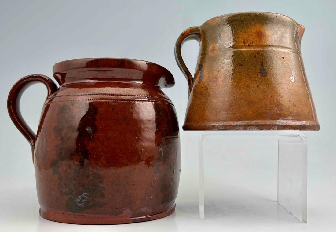 Two Early American Glazed Redware Pitchers: Two Early American Glazed &Redware Pitchers. Smallest approximately 5.0L x 5.5W x 4.25H in. Largest approximately 5.5L x 7.0W x 4.5H in.