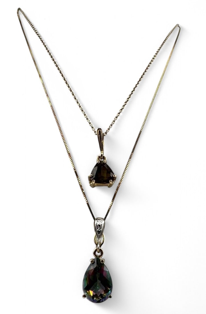 Two 10K Topaz Necklaces: Two 10K Topaz Necklaces, 5.5g. Marked 10K. Mystic topaz approximately 12.0 x 8.0 mm, chain length 20.0in. Golden topaz approximately 7.5mm, chain length 18.0 in. All measurements are approximate. ALL