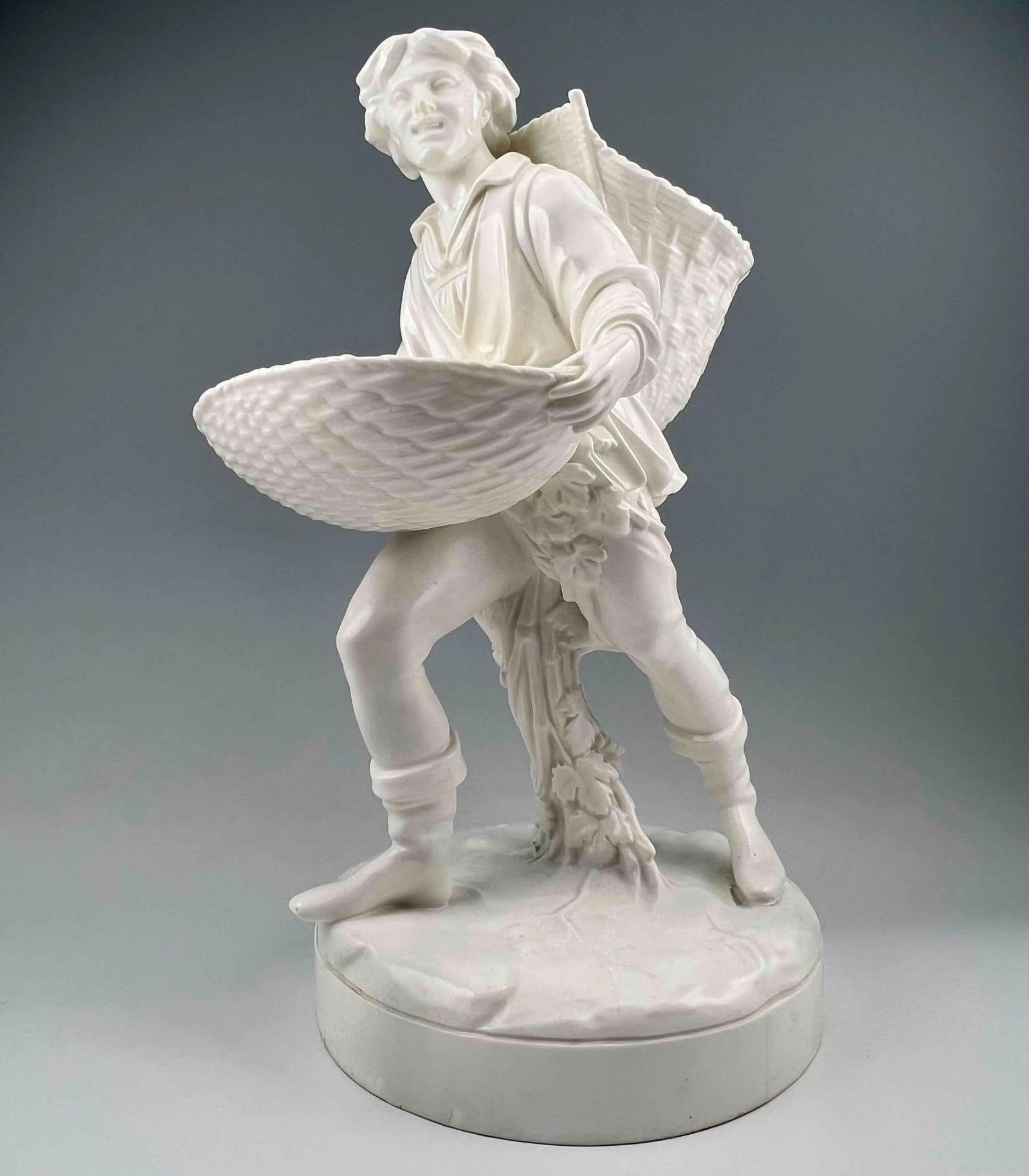 19th Century Minton White Glazed Figure Of A Man With Baskets: 19th Century Minton White Glazed Figure Of A Man With Baskets. Approximately 13.75H x 7.75W x 9.125D in.PLEASE NOTE THAT WINNING BIDDERS DO NOT NEED TO SELECT THE LIVESHIPPING OPTION. OTHER SHIPPERS A