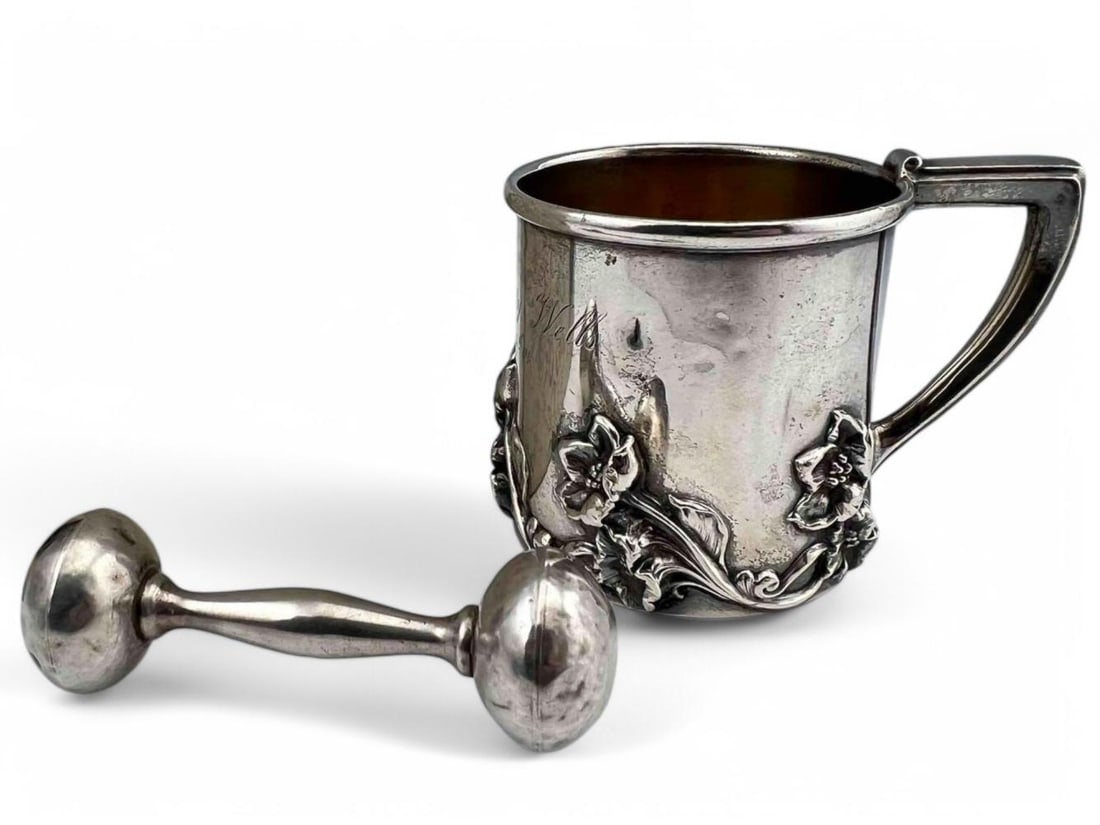 Sterling Silver Baby's Cup & Rattle: Sterling Silver Baby's Cup & Rattle, 166.6g total weight. Cup marked "Sterling." Rattle unmarked, tests as sterling. Cup approximately 3.0H x 4.125L x 3.0W in. Rattle approximately 4.0L x 1.25W in. AL