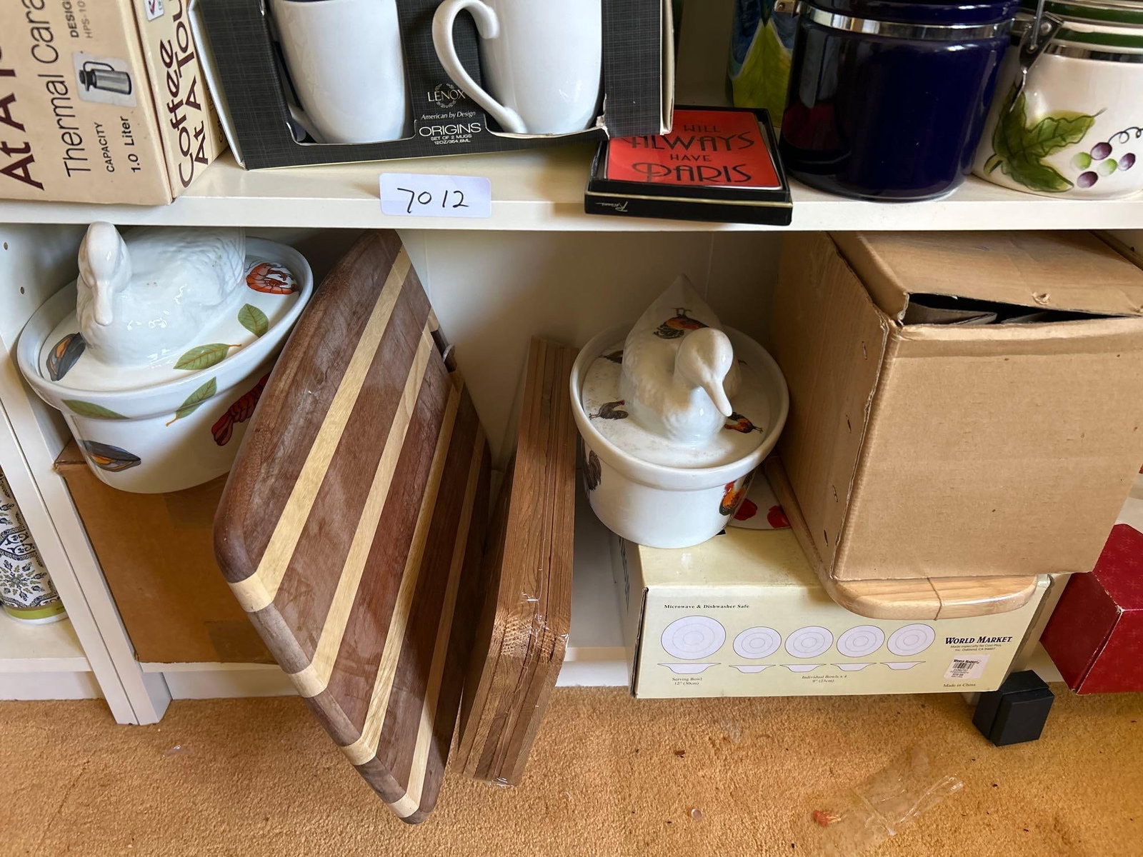 Covered Casserole Dishes, Cutting Boards, World Market Plates.: Bottom shelf of four covered casserole dishes, cutting boards, world market plates.