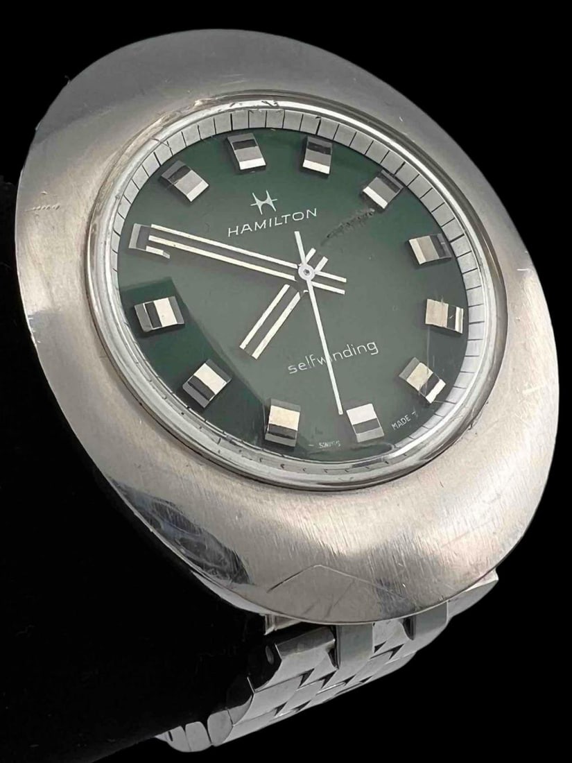 Hamilton Accumatic Self Winding Green Face Watch: Hamilton Accumatic Self Winding Green Face Watch. Features iconic mid century modern "egg case." Running intermittently. Inner band circumference approximately 7.25in. Watch approximately 1.8L x 1.5W