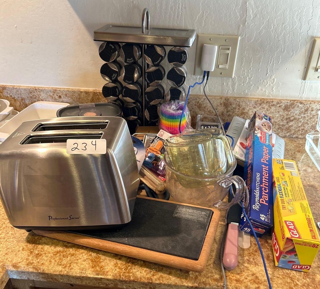 Grouping Of Kitchen Items To Include Toaster, Spice Rack, Parchment Paper, And More: Grouping of kitchen items to include toaster, spice rack, parchment paper, and more. Does not include charging cords or plug.