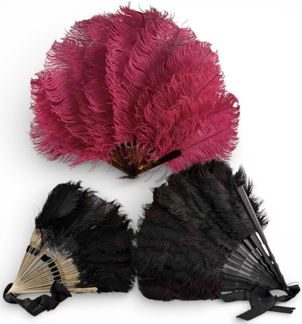 19th-20th C. Ostrich Feather Folding Fans: 19th-20th C. Ostrich Feather Folding Fans. Larger black feather fan (open) approximately 24.0W x 15.0H in. Smaller black fan with gilt painted sticks (open) approximately 16.0W x 13.25H in. Pink feath