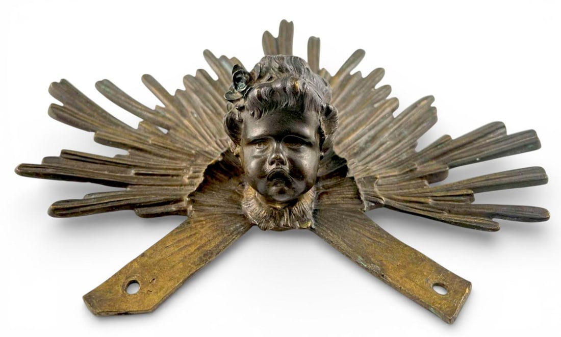 Baroque Style Bronze Cherub Head Sunburst Mount: Bronze Cherub Head With Radiating Sunburst Halo, 19th Century. Cast bronze with central mounting socket and integral attachment tabs, indicating it was originally part of a larger ecclesiastical objec