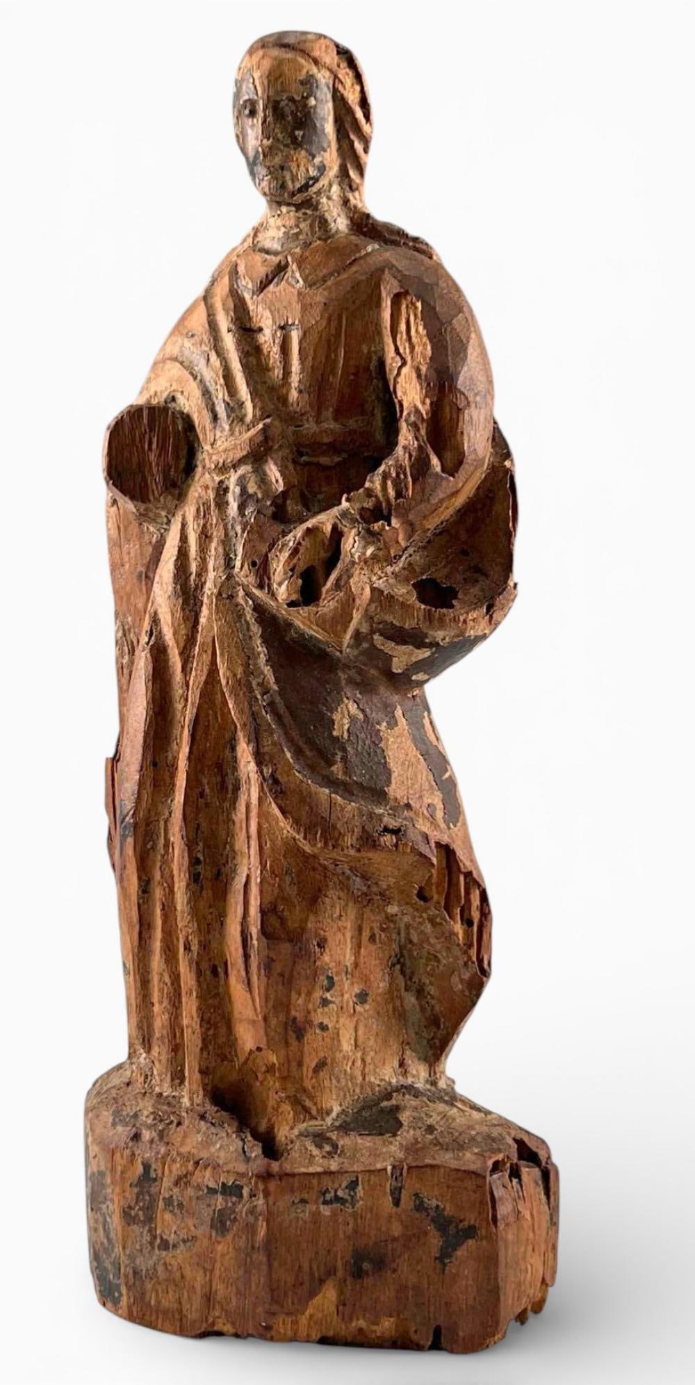 Early Spanish Colonial Carved Wood Santos Of An Apostle: Early Spanish Colonial Carved Wood Santos, Likely Depicting An Apostle, Shown Holding A Book, C. 17th Century. Carved in the round from a single block with integral base, retaining traces of original