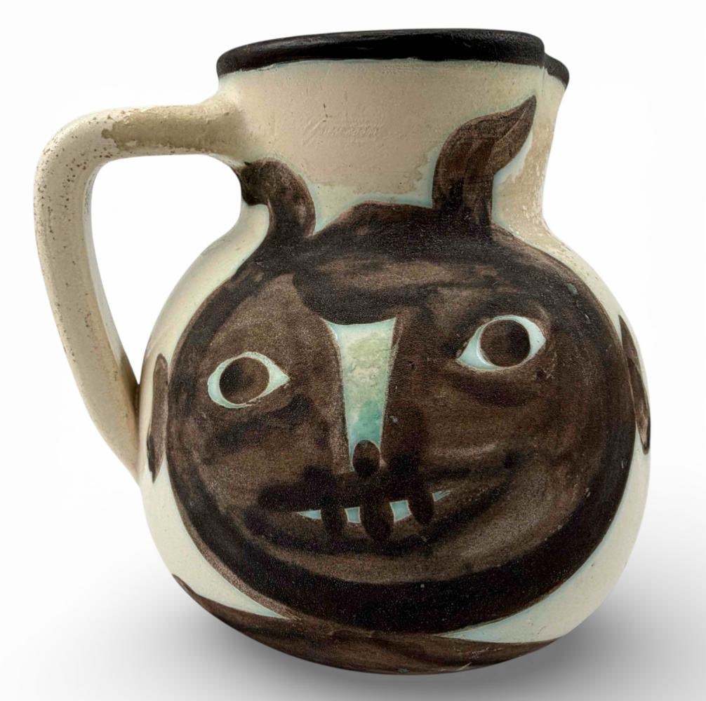 Pablo Picasso (1881-1973), Madoura "Tetes" (Heads) No. 367 Ceramic Pitcher, 1956: Pablo Picasso (1881-1973), Madoura "Tetes" (Heads) No. 367 Ceramic Pitcher, 1956. Glazed earthenware ceramic pitcher decorated with stylized faces in black oxide on a white ground. Produced at Madoura
