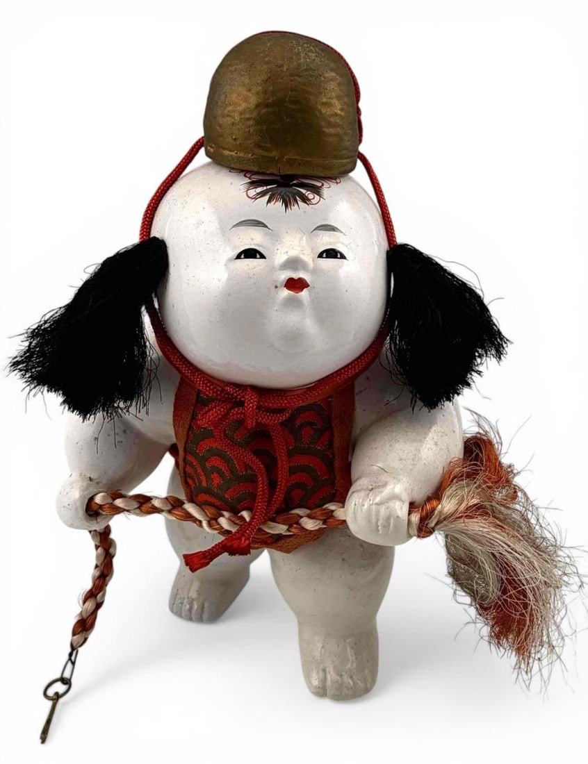 Japanese Gosho Ningyo (Palace Doll) With Braided Rope: Japanese Gosho Ningyo (palace doll) depicting a child holding a braided rope with finely painted features and white gofun finish. The figure wears a silk brocade vest and features a gilt cap element w