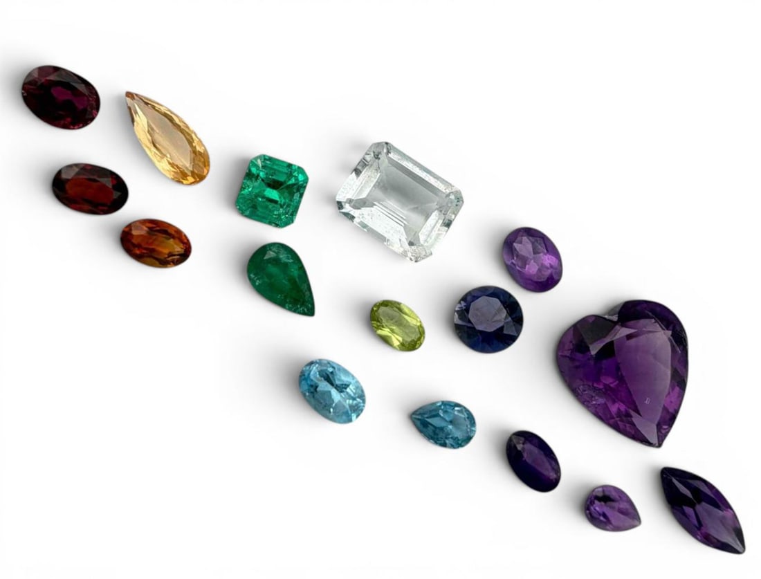 Grouping Of Unmounted Gemstones: Grouping Of Unmounted Gemstones. Includes Emeralds, Ruby, Amethyst, Golden Topaz, Blue Topaz, Iolite, Peridot, and Quartz. Emeralds approximately 6.3 x 5.9mm and 7.9 x 4.9mm. Ruby approximately 6.8 x