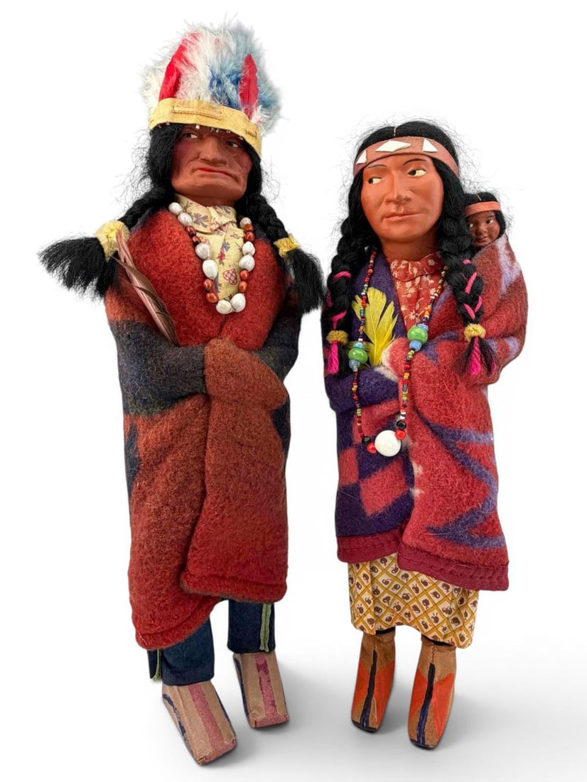 Pair Of Vintage Skookum Dolls: Pair Of Skookum "Bully Good Indian" Dolls. Attached labels marked "Skookum (Bully Good) Indian U.S.A." Male "Chief" doll approximately 15.0H x 4.25W in. (includes headdress). Female doll with baby app
