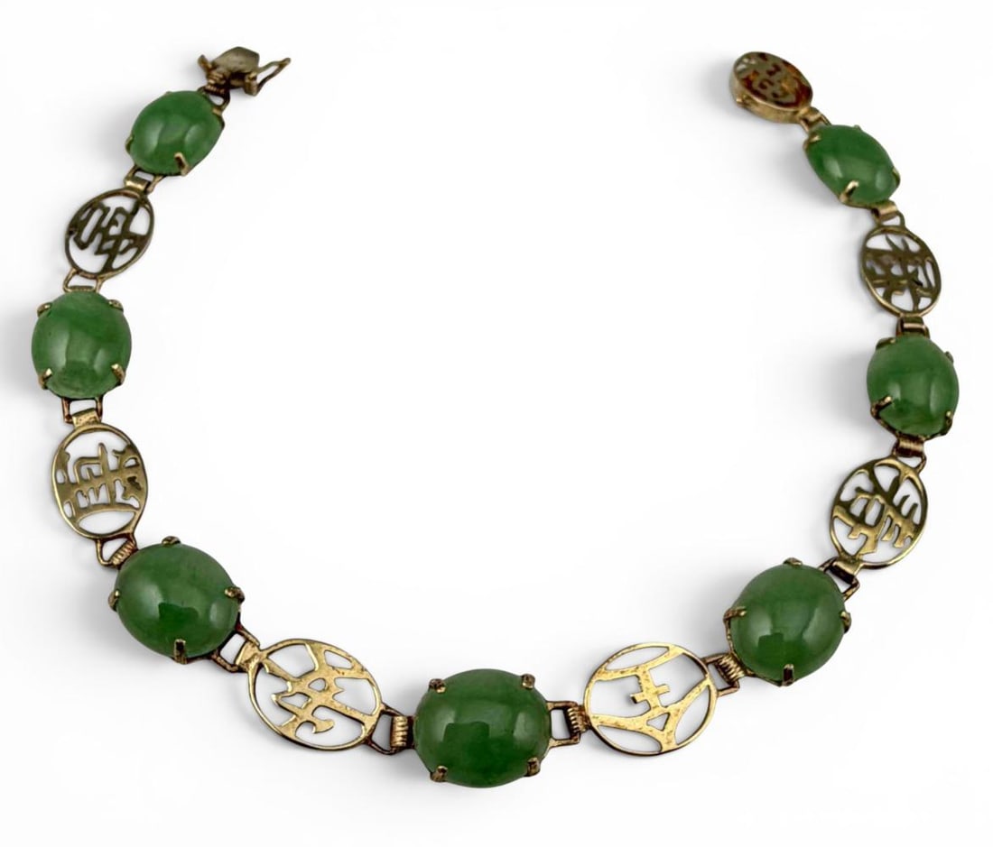 14K Jade Chinese Character Bracelet: 14K Jade Chinese Character Bracelet, 6.4g. Marked "14K 585." Inner circumference approximately 7.0in. Width approximately 8.0mm. Jade cabochons approximately 9.7 x 7.8mm. ALL CREDIT CARDS WILL BE MANU