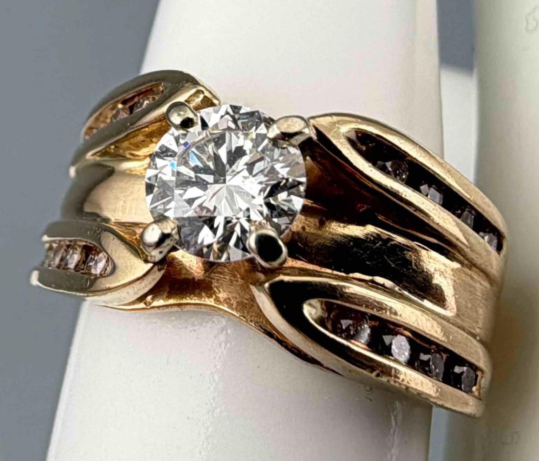 Vintage 14K Diamond Solitaire Ring: Vintage 14K Diamond Ring, 7.9g. Marked 14K. Features a round brilliant cut center diamond measuring approximately 5.7mm, set in yellow gold, flanked by (16) channel set diamonds to either side. Approx