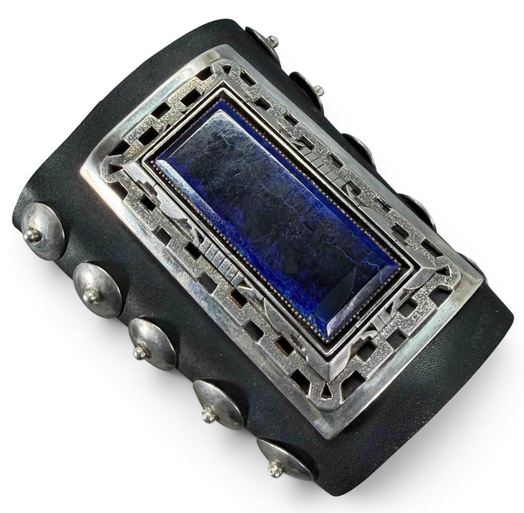 Navajo Sterling Silver Ketoh Bow Guard Bracelet: Navajo Sterling Silver Leather Ketoh Bow Guard Bracelet. Bracelet inner circumference 12.0in. Width 4.87in. Central sterling silver piece approximately 3.93L x 2.30W in. All measurements are approxima