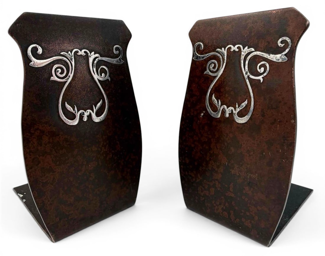 Heintz Sterling Silver Patinated Bronze Arts & Crafts Bookends: Heintz Sterling Silver Patinated Bronze Arts & Crafts Bookends. Marked with Heintz Art Metal Shop monogram, and "7155 Sterling on Bronze Pat. Aug.27.12." Approximately 3.5H x 2.12W x 2.25D in.