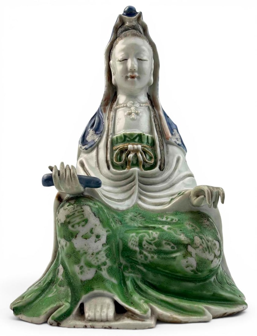 Chinese Porcelain Seated Guanyin Figure: Chinese porcelain figure of Guanyin seated in flowing robes, decorated with blue and green glaze accents. The figure holds a scroll-form object and wears a beaded necklace, with molded drapery and inc