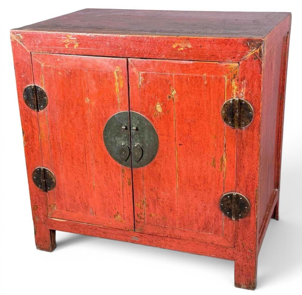 Chinese Red Lacquer Two Door Cabinet: Chinese Red Lacquer Two Door Cabinet. Chinese red-lacquer cabinet with two paneled doors, large circular brass lock plate with drop pulls, opening to a shelved interior with two upper drawers. Approxi