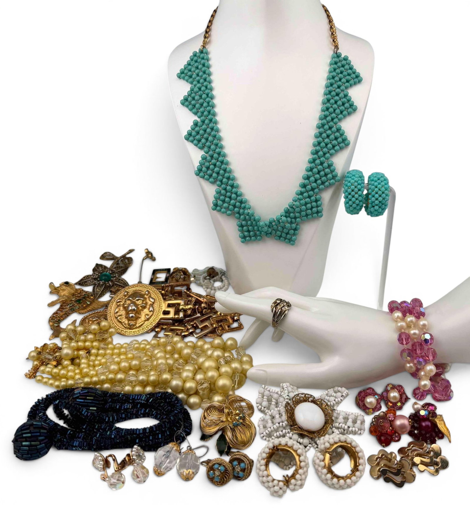 Grouping Of Vintage Mid Century Costume Jewelry: Grouping Of Vintage Mid Century Costume Jewelry. Includes glass beads, faux pearls, rhinestones, brooches, necklaces, earclips, and gold-tone lion belt. Clasp of pink glass bead and faux pearl