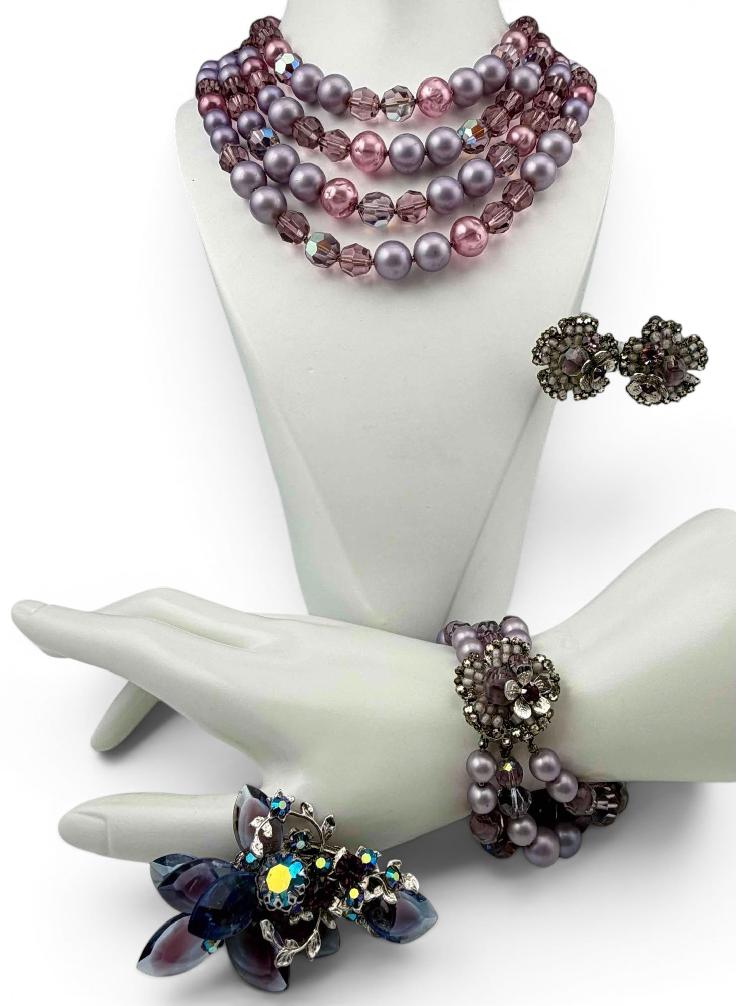 Group of Robert DeMario Purple Glass & Rhinestone Costume Jewelry: Group of vintage Robert DeMario costume jewelry, including a four strand purple faux pearl and faceted glass bead necklace, matching multi strand bracelet and clip earrings, and a purple glass floral