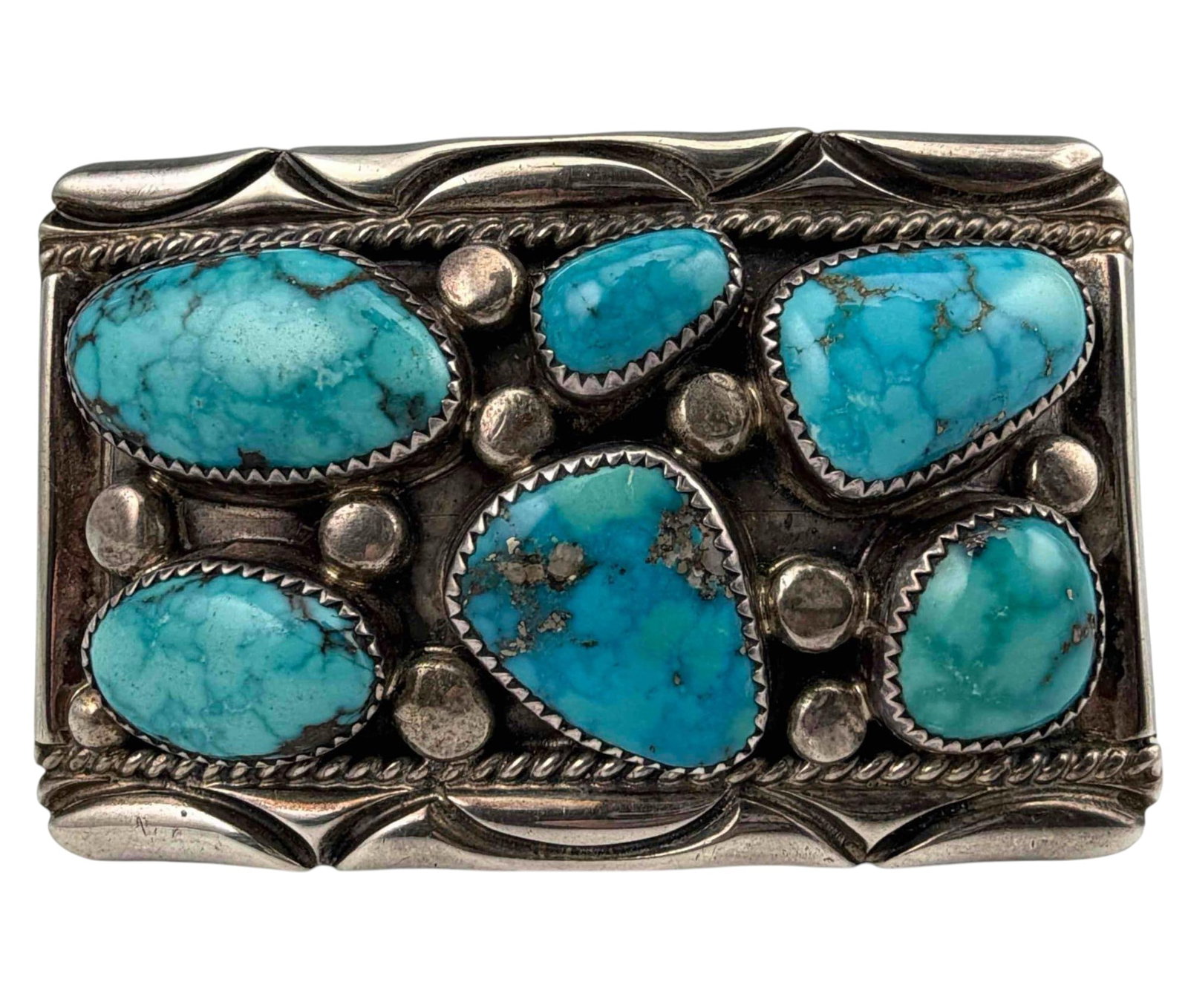 Orville Tsinnie, Navajo Sterling Silver Turquoise Belt Buckle: Orville Tsinnie, Navajo Sterling Silver Turquoise Belt Buckle, 62.0g. Signed "Orville Tsinnie of New Mexico." Approximately 1.72H x 2.69W in. Largest turquoise piece approximately 24.0 x 12.6mm.