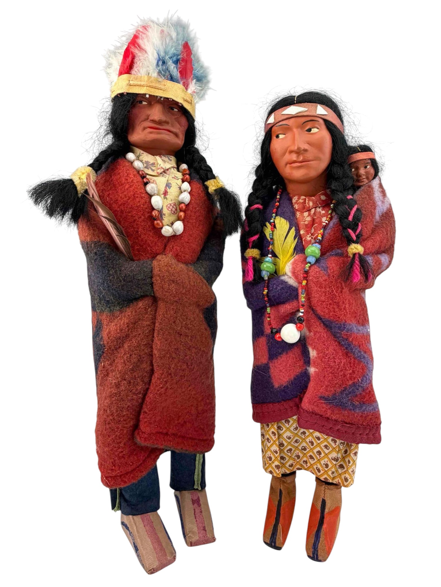 Pair Of Vintage Skookum Dolls: Pair Of Skookum "Bully Good Indian" Dolls. Attached labels marked "Skookum (Bully Good) Indian U.S.A." Male "Chief" doll approximately 15.0H x 4.25W in. (includes headdress). Female doll with baby app