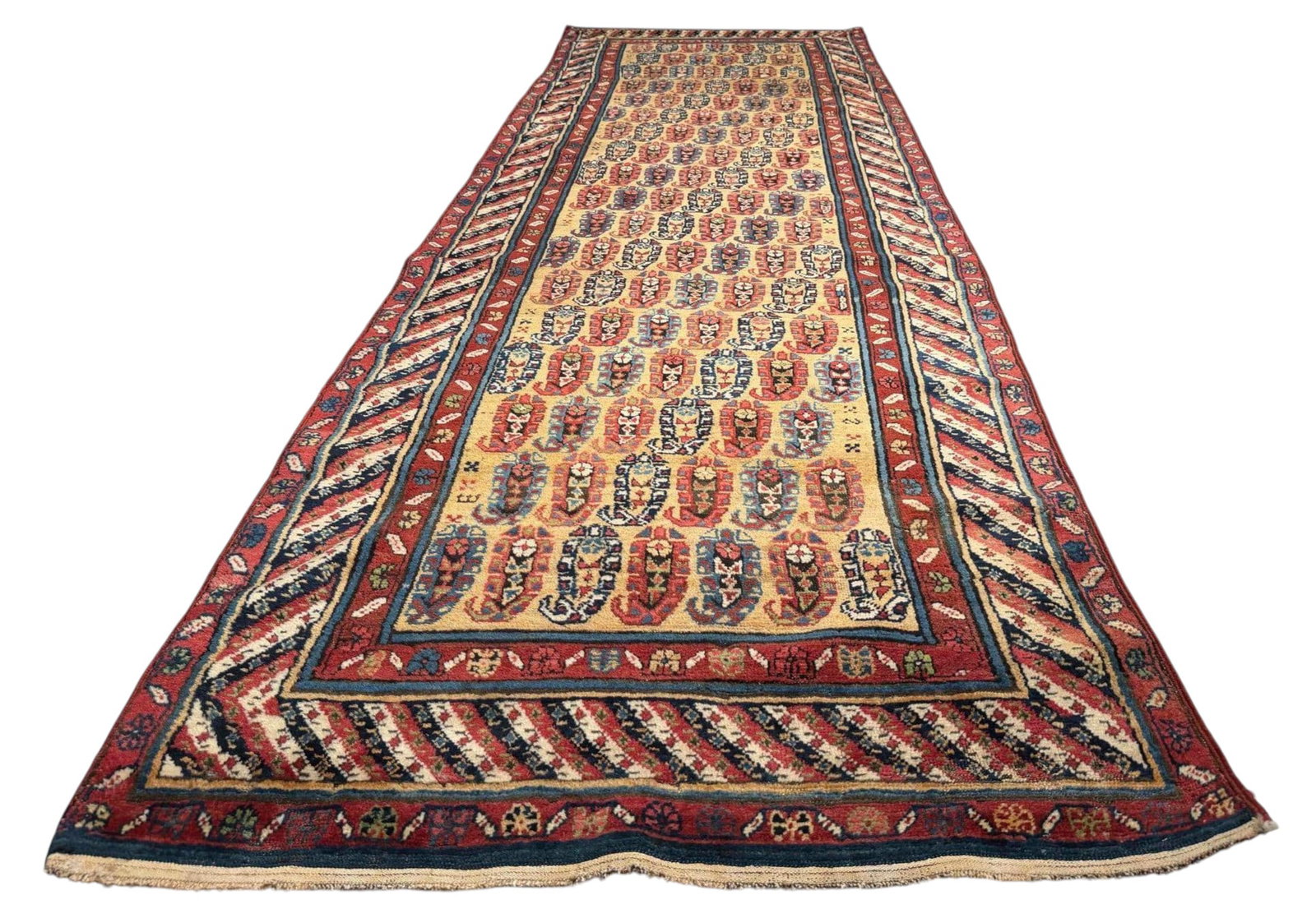 Caucasian Genje Runner Rug: Caucasian Genje Runner Rug. Hand-knotted wool runner with an ivory field, framed by red floral borders and a prominent diagonal-striped main border in red, ivory, and dark blue. Approximately 10.75L x