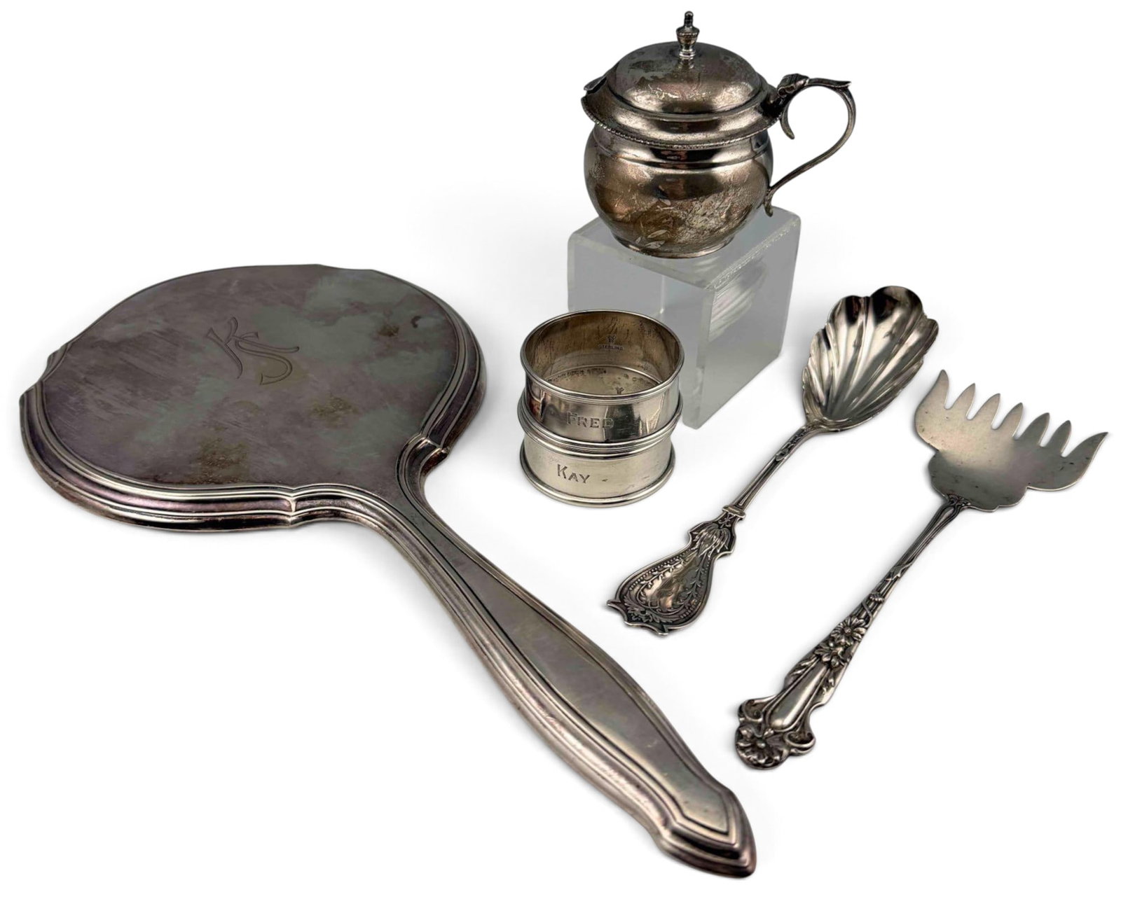 Grouping Of Silver Tableware & Mirror: Grouping Of Silver Tableware & Mirror. Sterling pieces 117.3g. Marked sterling. Mirror marked 800. Includes mustard pot, napkin rings, fish fork, mirror, and sugar spoon. Mirror approximately 11.12L