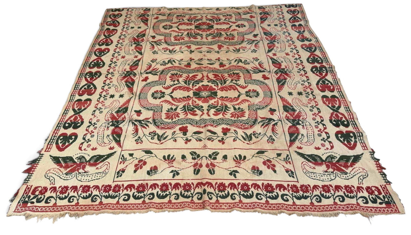 American Eagle and Floral Jacquard Coverlet, 19th Century: Jacquard coverlet woven in red, green, and natural tones with spread-winged eagles, stars, floral medallions, and foliate borders. Reversible double-weave construction with fringed end. Unmarked.