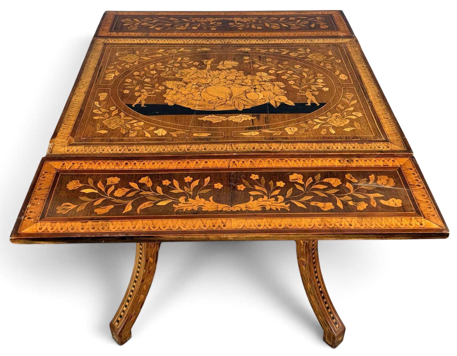 Continental Marquetry Expanding Games Or Tea Table: Continental Marquetry Expanding Games Or Tea Table. Continental walnut and fruitwood marquetry expanding table, likely 19th century. Inlaid with a central basket of fruit flanked by putti and surround
