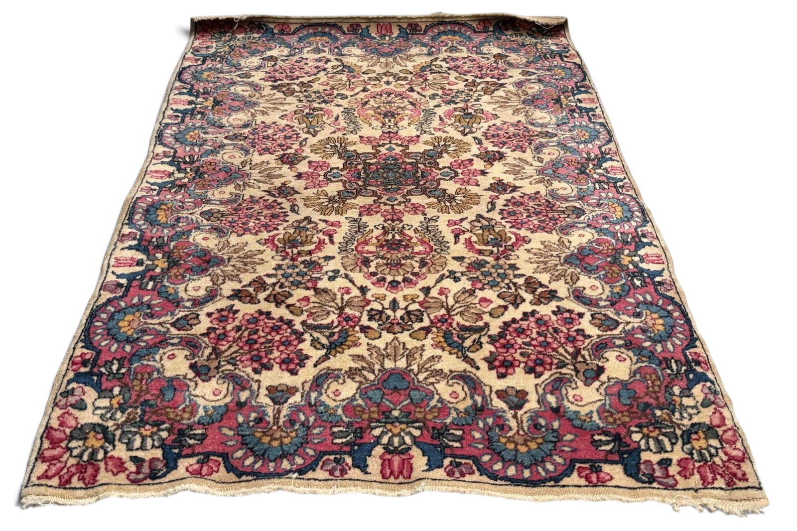 Persian Kerman Rug: Persian Kerman Rug. Hand-knotted wool rug with an ivory field centered by a small floral medallion and filled with scrolling vines, flowering sprays, and clustered blossoms in rose, blue, green, tan, 