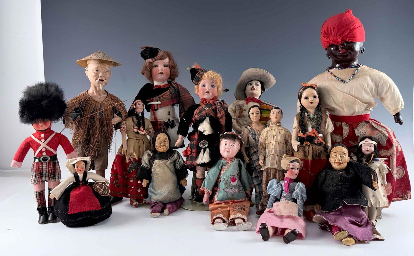 Grouping Of Vintage International Dolls: Grouping of vintage international and ethnic costume dolls, including a pair of Scottish dolls in tartan dress, a Mexican-style cowboy/charro doll with sombrero and striped serape, an Asian silk-dress