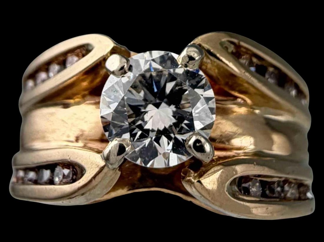 Vintage 14K Diamond Solitaire Ring: Vintage 14K Diamond Ring, 7.9g. Marked 14K. Features a round brilliant cut center diamond measuring approximately 5.7mm, set in yellow gold, flanked by (16) channel set diamonds to either side. Approx