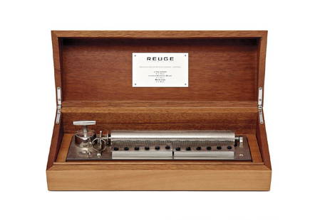 A MUSIC BOX, REUGE 20th Century: In wood box, inlaid on the cover in geometrical patterns, in original box, working. Original plate on the inside of the cover ‘Reuge Mouvement Sublime Harmonie 144 lames – 3 mélodies.