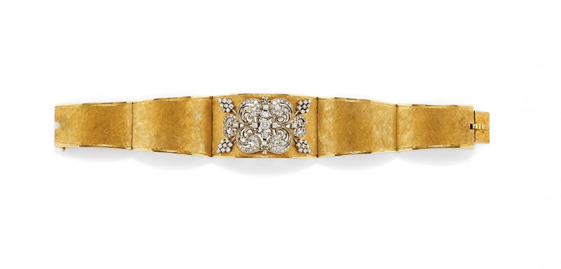 diamond bangle: DIAMOND BANGLE designed as a tapered brushed yellow gold articulated band centring a naturalistic motif in pierced white gold adorned with diamonds weighing approx. 0.90 ct overall. Circa 1950.