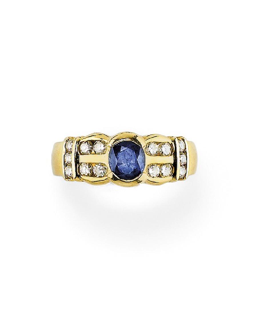 BLUE SAPPHIRE AND DIAMOND RING: BLUE SAPPHIRE AND DIAMOND RING in yellow gold with oval blue sapphire weighing approx. 0.80 ct flanked by brilliant-cut diamonds weighing approx. 0.50 ct.