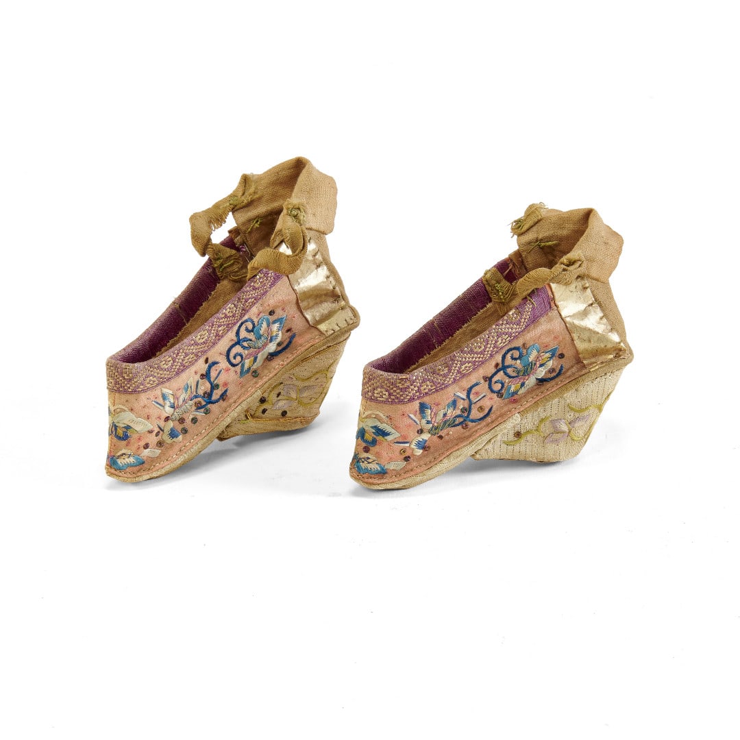 PAIR OF SMALL LOTUS SHOES China, early 20th century: Silk, pink ground with floral decoration embroidered with polychrome threads. 3.1 x 1.6 x 3.3 in.