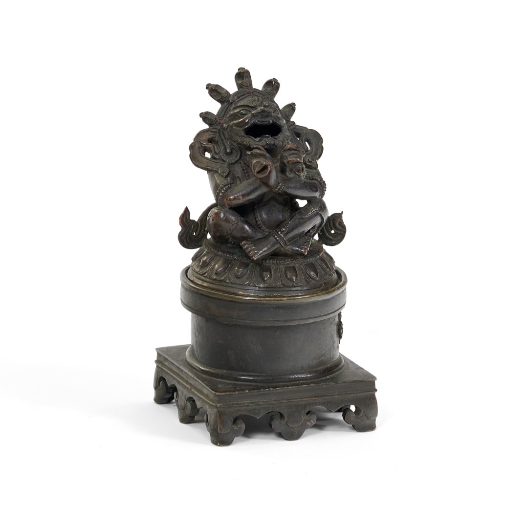 Incense burner Tibet, 19th-20th century: Bronze, the lid with Makahala seated on a lotus flower base, the cylindrical container with a square-section base decorated on the front with a vajra, the back of the head with traces of red pigment.