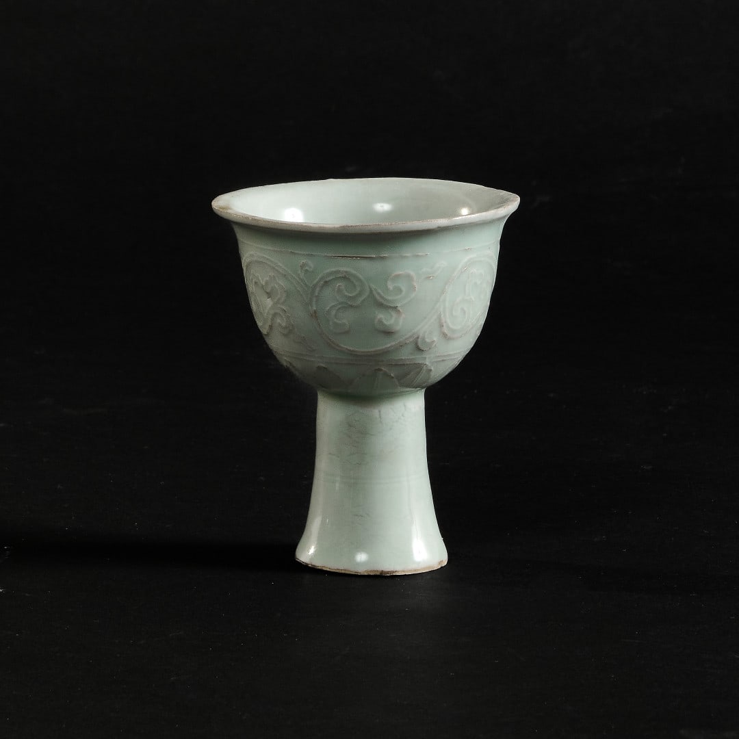 Small stem cup China, 20th century: Porcelain with qingbai glaze, relief decoration of floral motifs. 3.7 x 3.1 in.
