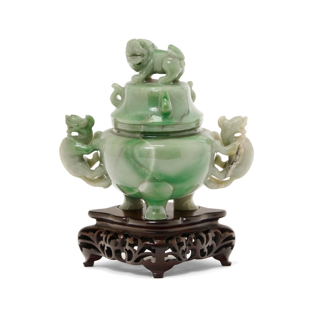 Incense burner with cover China, 20th century: Green stone, the body supported by three feet, the lid with two small handles and a Buddhist lion as finial, wooden base. 6.5 x 6.1 x 3.7 in.