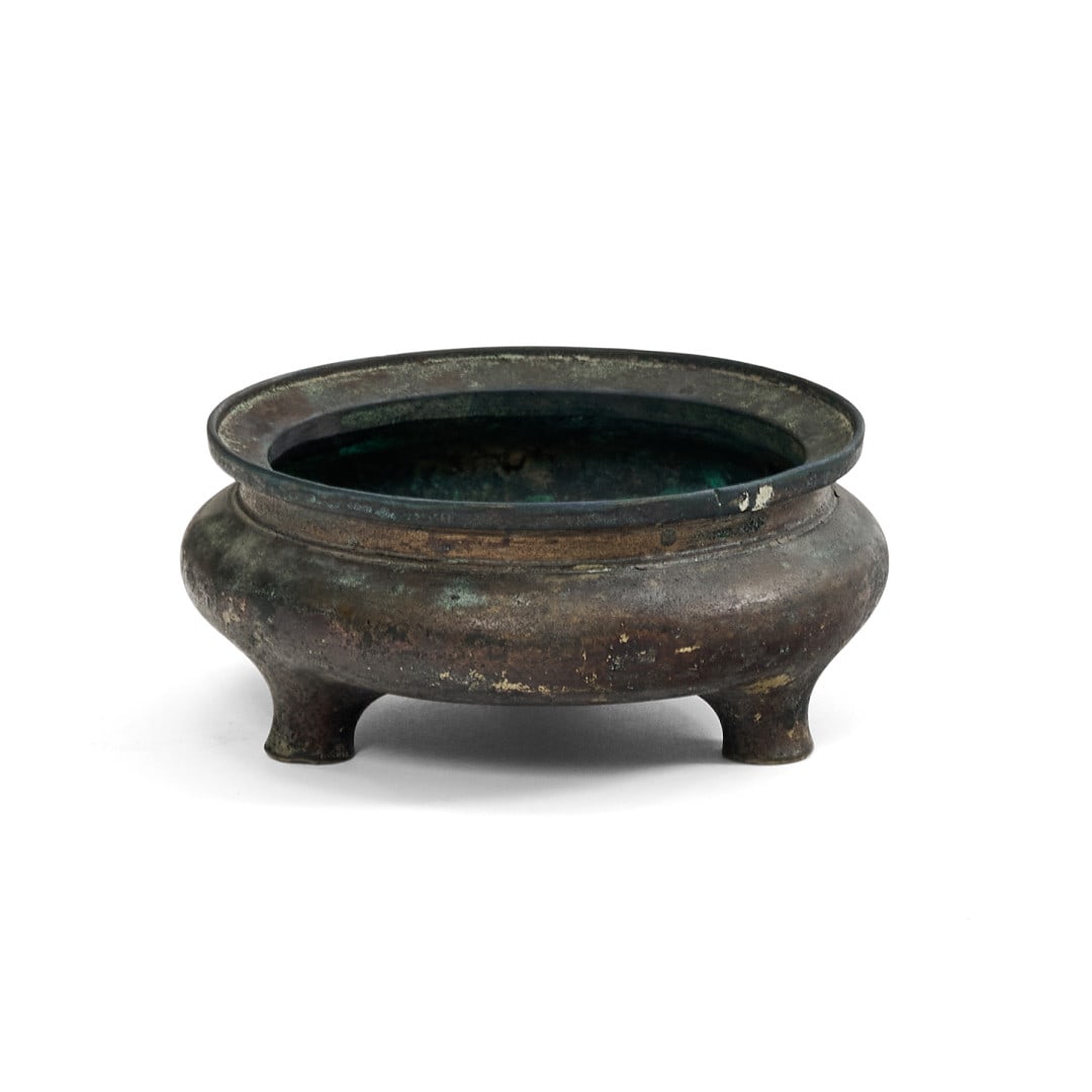 Incense burner China, 20th century: Bronze, the container supported by three feet, mark to the centre of the base. 2 x 4.5 in.