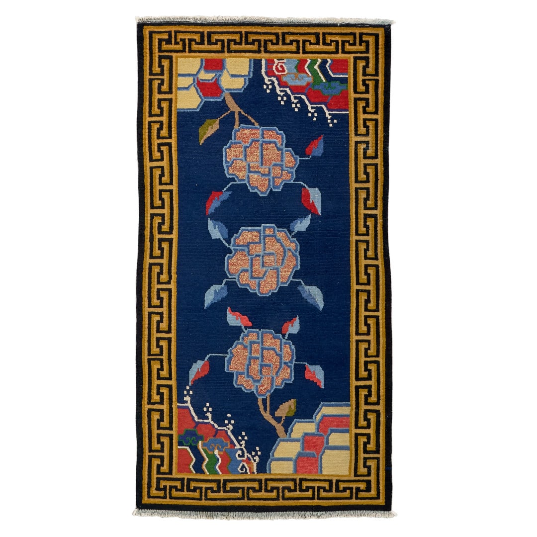 Carpet, khaden Tibet, 20th century: Blue ground with polychrome decoration of peonies, stylised rocks and waves, geometric border. A 'classic' motif in Tibetan khaden carpet production, used in homes and tents, and characterised by