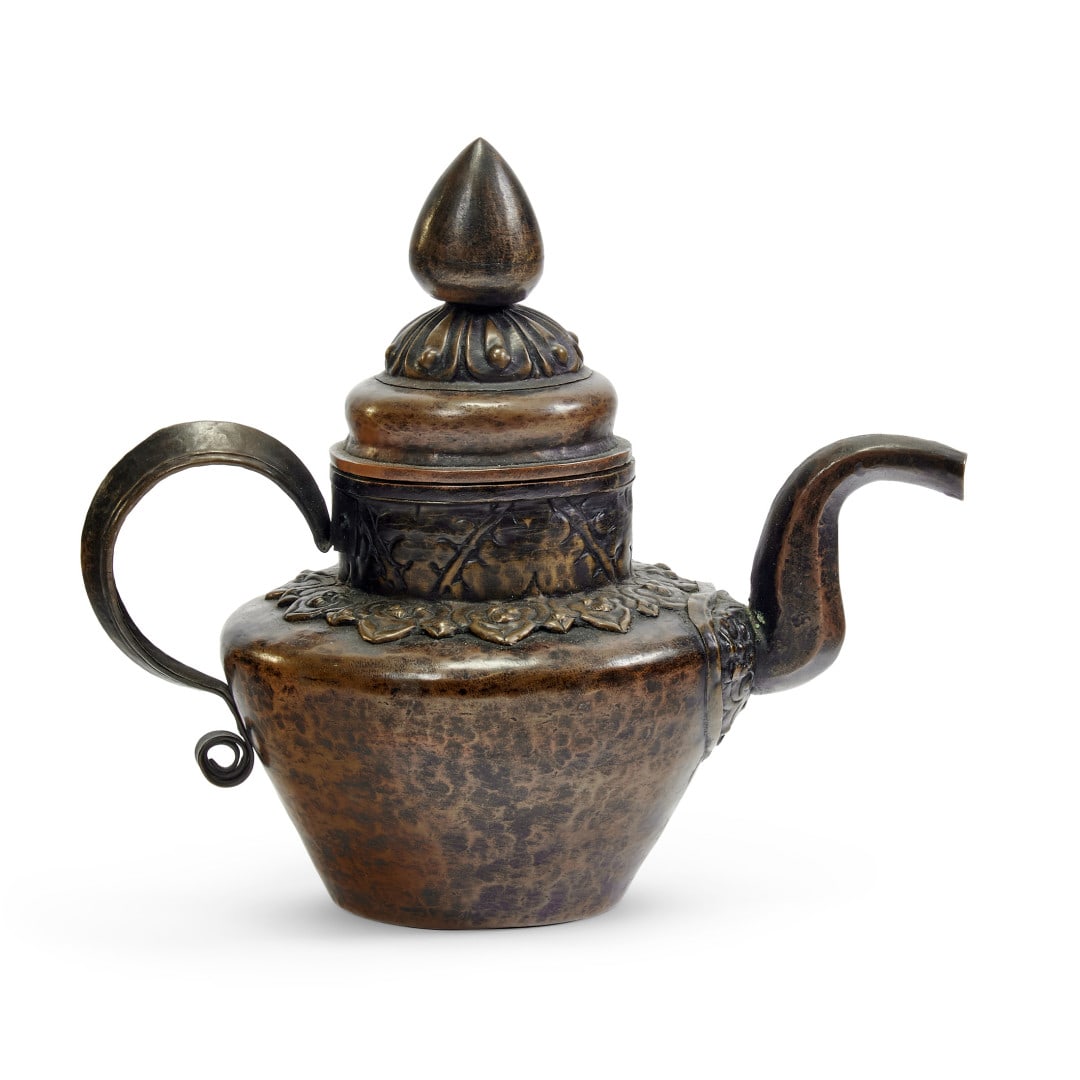 Ewer with lid Tibet, 20th century: Embossed copper, curved spout and handle, lid with pine cone finial, relief floral decoration on the shoulder and neck. 7.9 x 9.4 x 5.5 in.