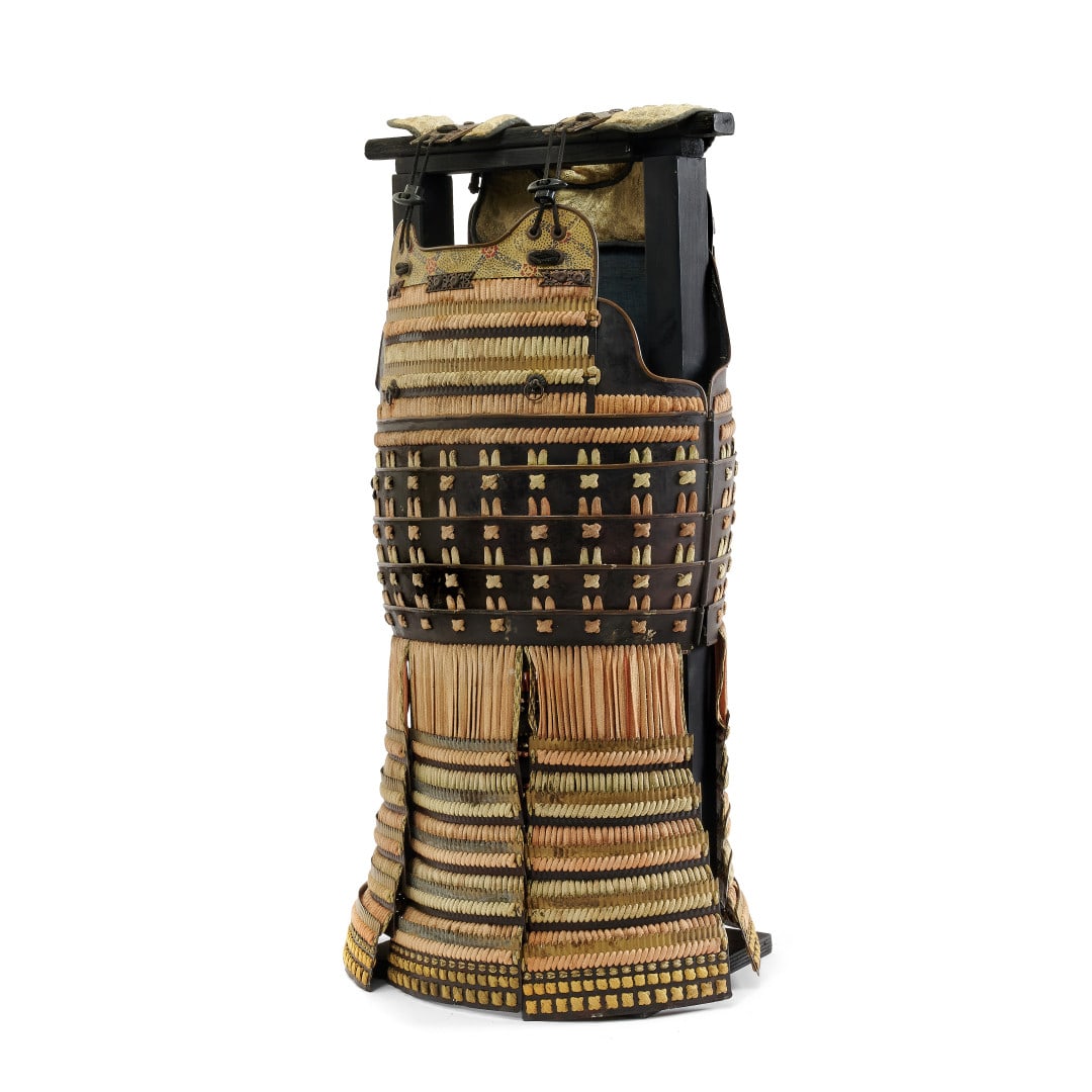 PART OF ARMOR Japan, 19th-20th century: Silk, leather and metal accessories, armor and upper leg protections, its wooden support. 33.1 x 15.7 in.