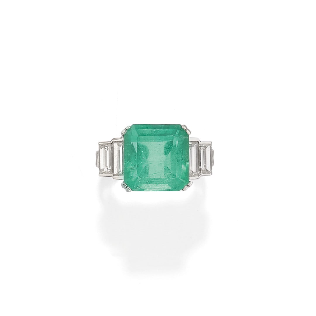 ANELLO IN SMERALDO E DIAMANTI - EMERALD AND DIAMOND RING: in oro bianco con uno smeraldo taglio ottagonale a gradini di ct 6,591 affiancato da quattro diamanti taglio baguette di ct 0,30 ca. complessivi. Accompagnato da certificato SSEF. Gr 7,20 - nr 7,5 - i