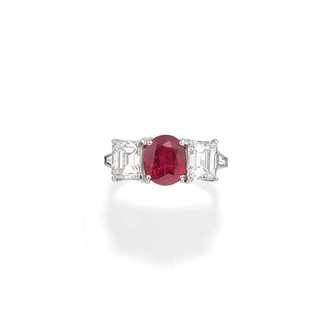 ANELLO IN DIAMANTI E RUBINO - DIAMOND AND RUBY RING: in platino con un rubino centrale taglio ovale di ct 1,60 ca. affiancato da due diamanti taglio smeraldo di ct 1,60 ca. complessivi. Gr 5,50 - nr 9,5 - in platinum with a central oval-cut ruby weighin
