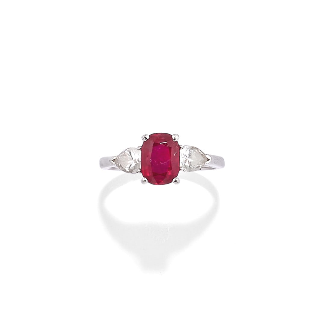 ANELLO CON RUBINO E DIAMANTI - RUBY AND DIAMOND RING: in oro bianco con un rubino centrale taglio ovale a cuscino di ct 1,00 ca. affiancato da due diamanti laterali taglio goccia di ct 0,40 ca. complessivi. Gr 3,60 - nr 10,5 - in white gold with a centra