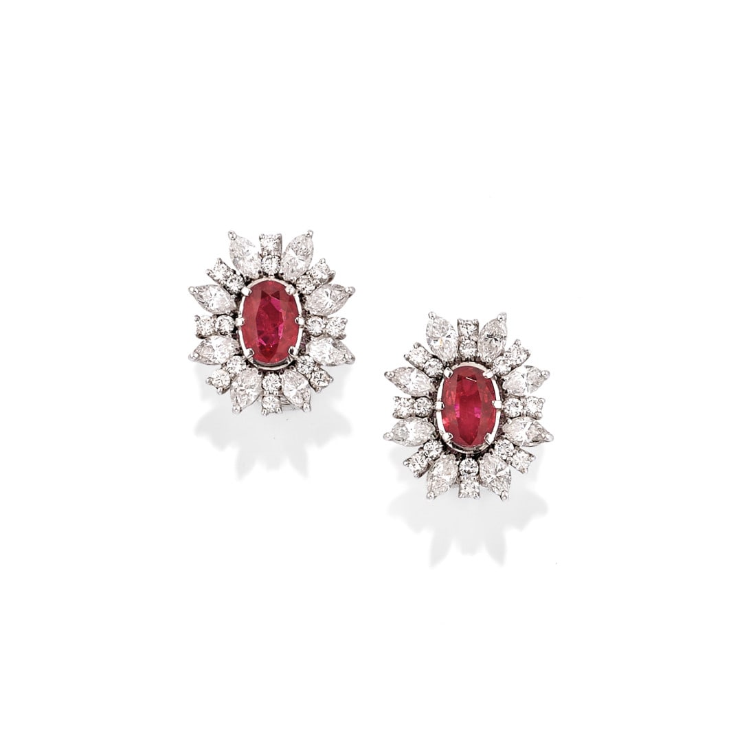 PAIO DI ORECCHINI A CLIP IN DIAMANTI E RUBINO - PAIR OF DIAMOND AND RUBY EAR CLIPS: in oro bianco a forma di fiore con al centro un rubino taglio ovale a cuscino di ct 1,50 ca. e petali e foglie in diamanti taglio brillante rotondo e marquise di ct 3,20 ca. complessivi. Gr 9,30 - cm