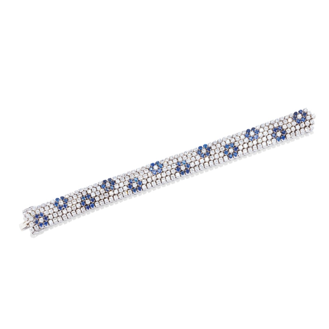 BRACCIALE IN DIAMANTI E ZAFFIRI - DIAMOND AND SAPPHIRE BRACELET: in oro bianco realizzato a cinque file di diamanti e zaffiri a formare un disegno di fiori blu. I diamanti sono di taglio brillante rotondo di ct 11,00 ca., mentre gli zaffiri, sempre di taglio brilla