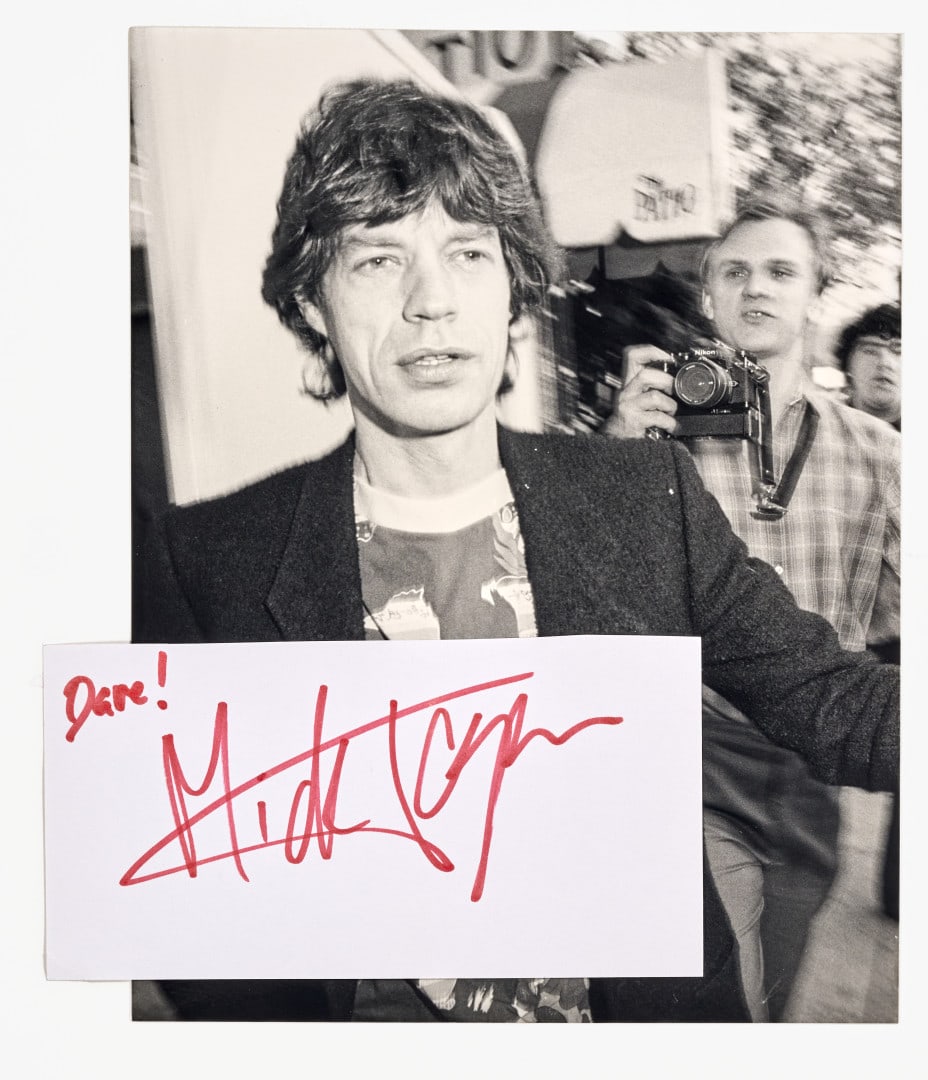 MICK JAGGER Signed photographic print 1983: Photographic print depicting Mick Jagger leaving a restaurant in Los Angeles, accompanied by a separate autograph signature 9.06 x 7.09 in.