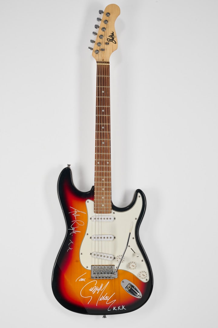 WHAM! Autographed electric guitar: Stratocaster-style electric guitar with sunburst finish and white pickguard, bearing the autograph signatures of George Michael and Andrew Ridgeley
